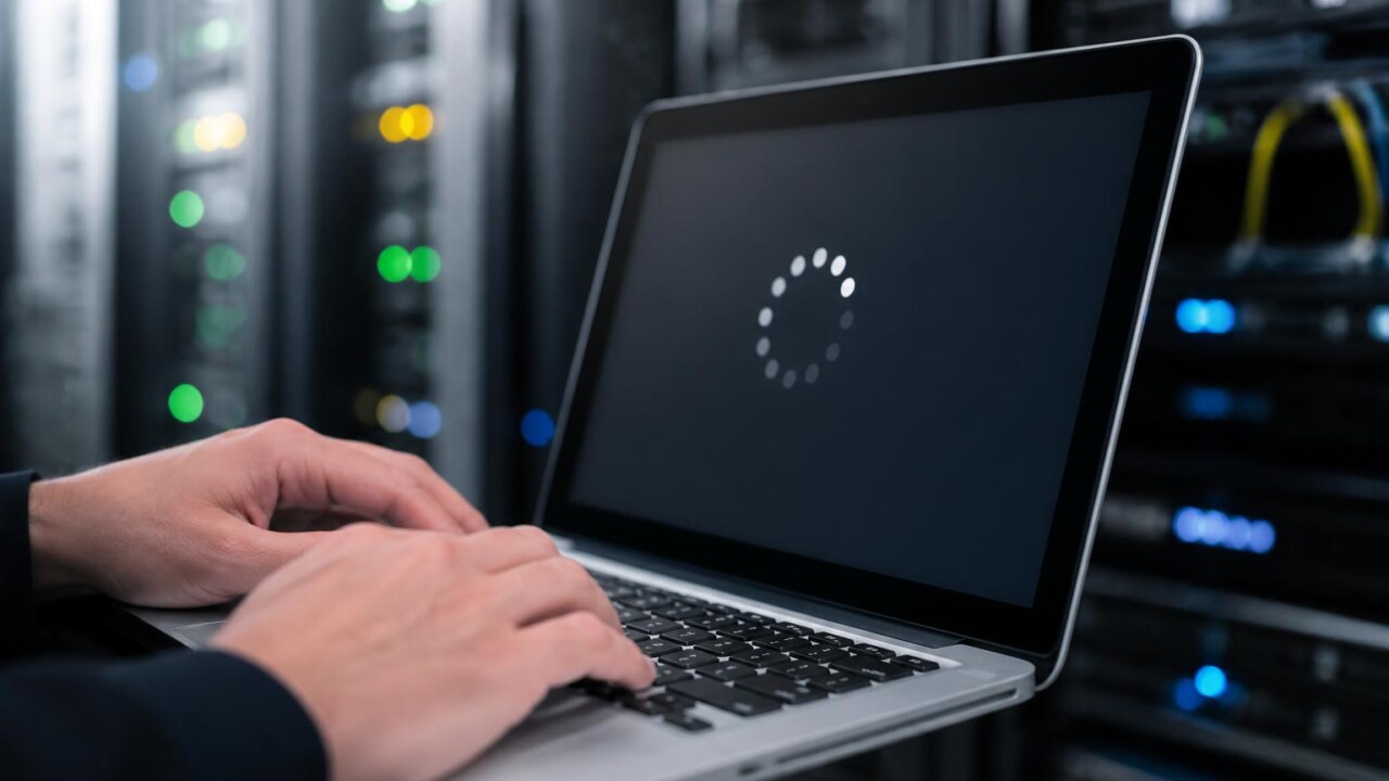 Pessoa aplicando atualização de segurança em laptop com servidor ao fundo