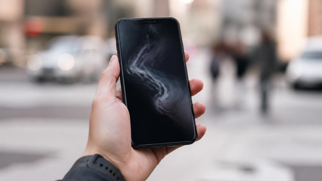 Pessoa segurando smartphone com tela de bloqueio em destaque