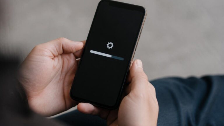 Pessoa segurando celular com tela de atualização travada