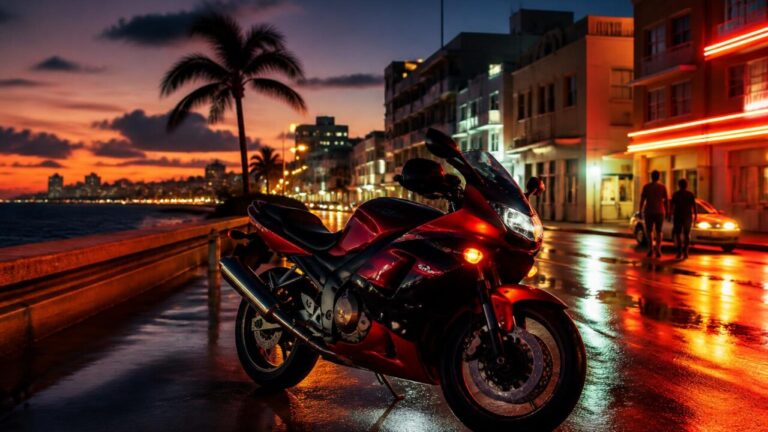 Motocicleta esportiva parada em avenida costeira de cidade ao anoitecer, com neon e prédios ao fundo.